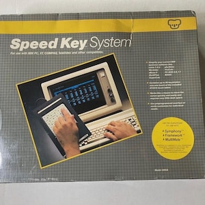 May include: A vintage Speed Key System box with a yellow and gray design. The box features the product name and an image of a computer setup with a keyboard and a keypad. The text on the box includes "Speed Key System" and "for use with IBM PC, XT, COMPAQ, TeleVideo and other compatibles."