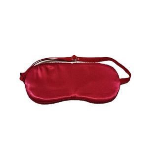 Puede incluir: Una máscara para dormir de satén rojo con una correa elástica ajustable.