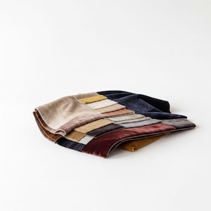 a collection of fabric swatches or samples, each with a different color and pattern, arranged on a white background.