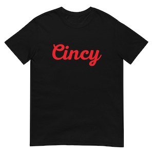 Puede incluir: Camiseta negra con la palabra "Cincy" en letras rojas cursivas.