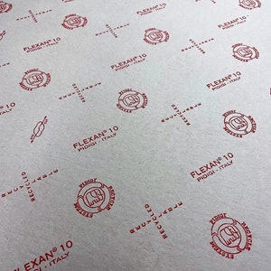 May include: A close-up of a white paper surface with a repeating pattern of red circular stamps. Each stamp features the text "FLEXAN® 10 PIDIGI ITALY" and a stylised recycling symbol.