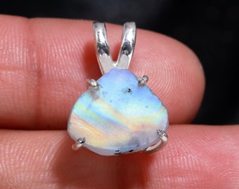 May include: A silver pendant featuring a blue and iridescent opal gemstone with a silver bail.
