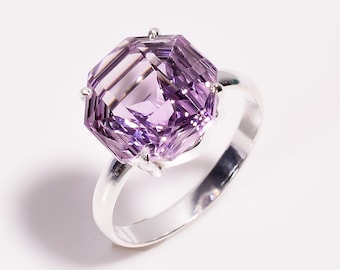 May include: A silver ring with a large, faceted amethyst gemstone. The gemstone is a deep purple color and has a square shape.