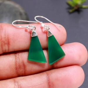 May include: A pair of silver dangle earrings with green gemstone triangle drops.