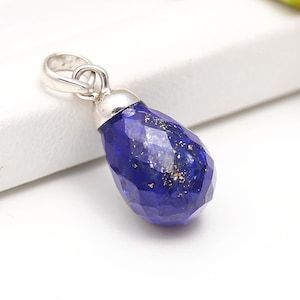 Op de afbeelding: Een traanvormige hanger gemaakt van lapis lazuli met gouden vlekken. De hanger is gezet in sterling zilver en heeft een lus om aan een ketting te bevestigen.