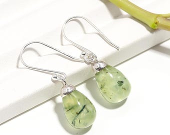 May include: A pair of silver earrings with green gemstone drops. The gemstones have a unique, speckled appearance.