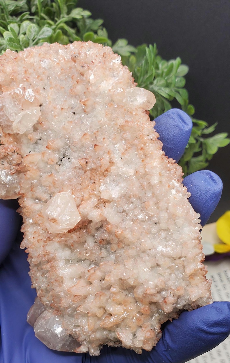K&ouml;nnte beinhalten: Ein Cluster aus wei&szlig;en und rosafarbenen Kristallen mit einer rauen, strukturierten Oberfl&auml;che. Die Kristalle sind in einem zuf&auml;lligen Muster angeordnet und haben ein nat&uuml;rliches, organisches Aussehen.