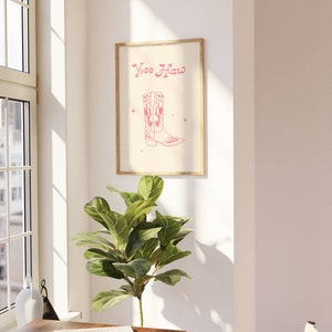 May include: A pink and white illustration of a cowboy boot with the text "Yee Haw" on a beige background.