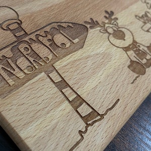 May include: A wooden cutting board with a reindeer and a sign that says "North Pole".