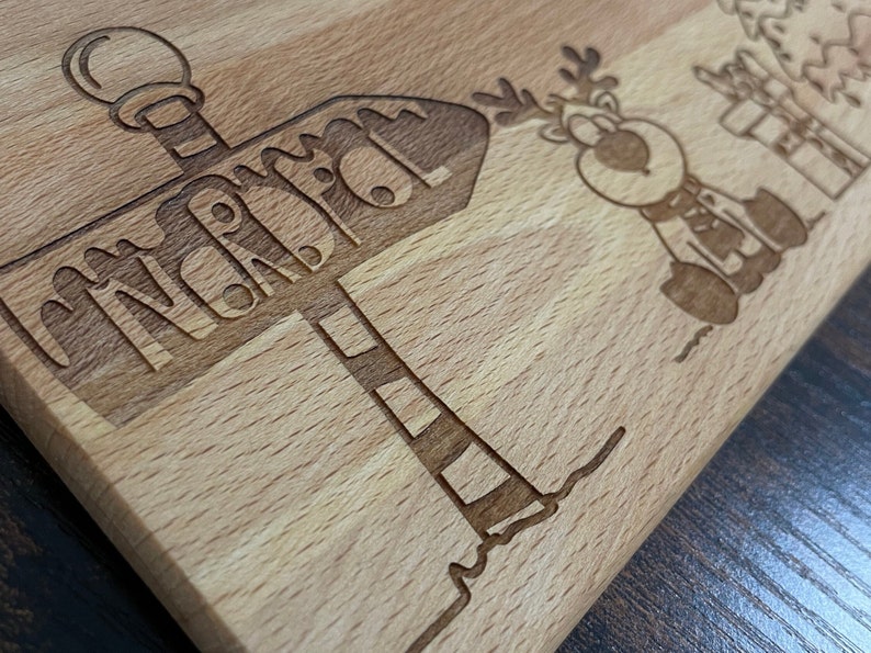 May include: A wooden cutting board with a reindeer and a sign that says "North Pole".