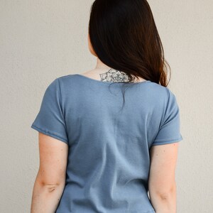 Puede incluir: Una camiseta azul de manga corta con cuello redondo. La camiseta est&aacute; hecha de tejido de canal&eacute; y tiene una longitud recortada.