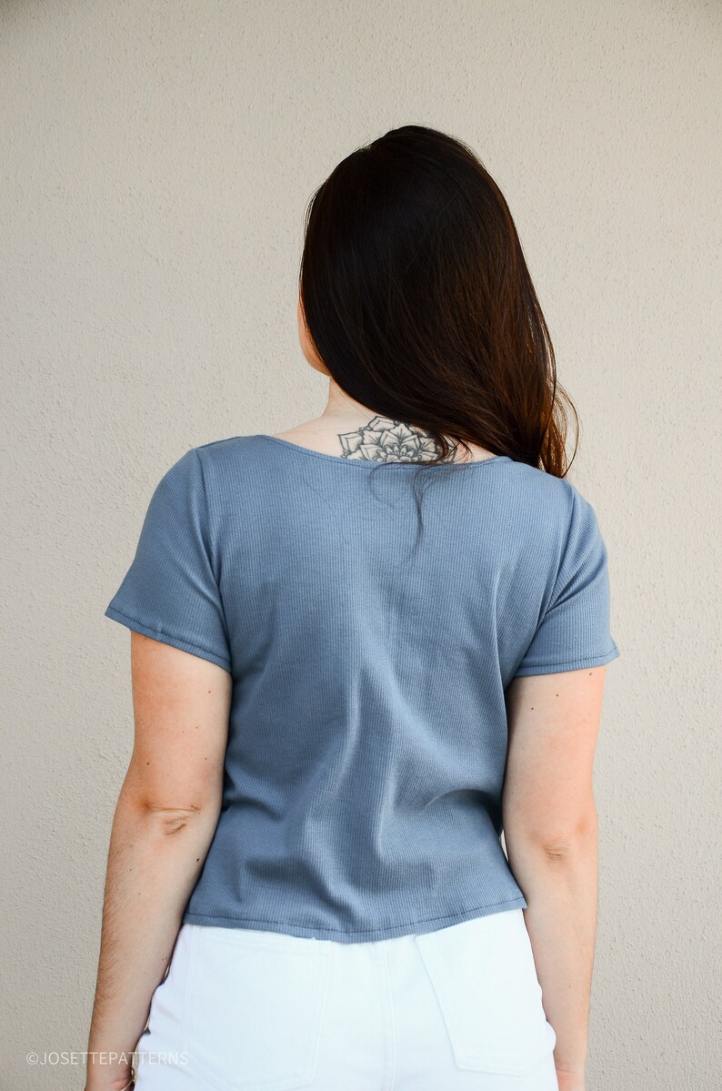 Puede incluir: Una camiseta azul de manga corta con cuello redondo. La camiseta est&aacute; hecha de tejido de canal&eacute; y tiene una longitud recortada.