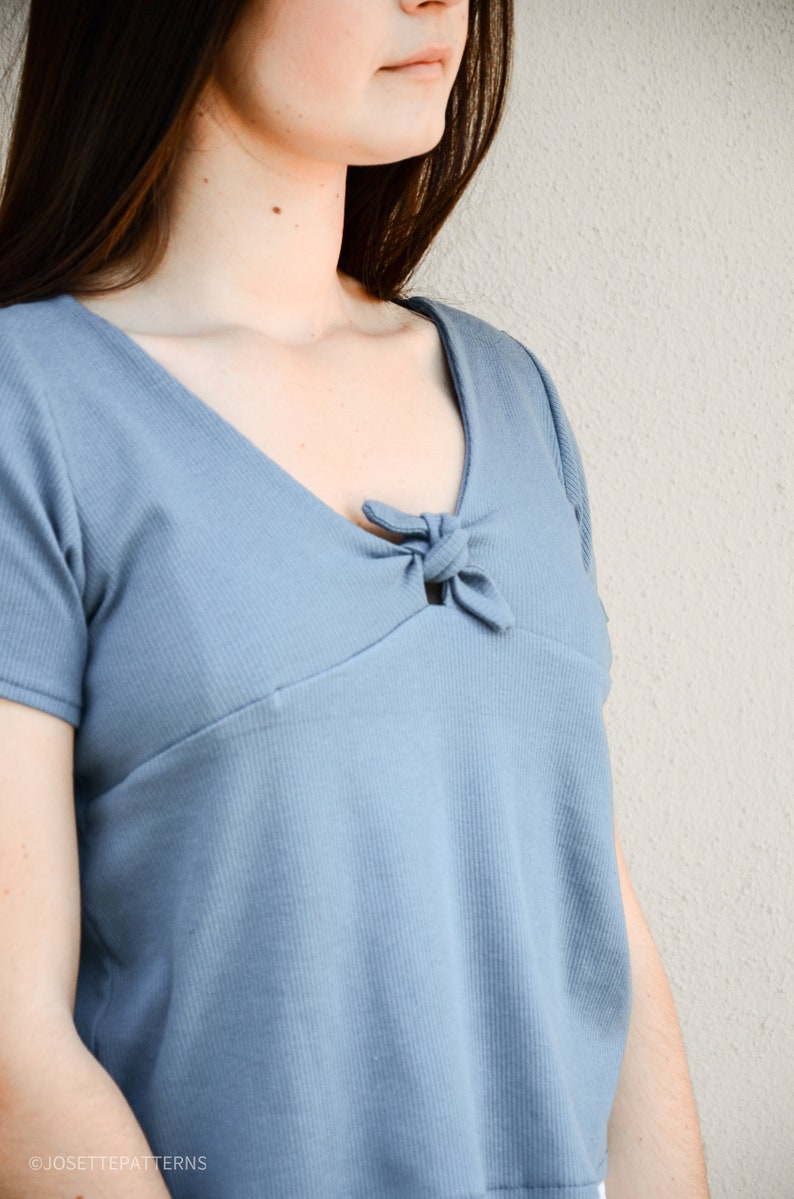 Puede incluir: Primer plano de un top azul de canal&eacute; con un detalle anudado en el escote.