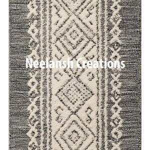May include: A rectangular rug with a central cream-colored design featuring geometric patterns, bordered by dark gray edges. The rug has a textured appearance and the text "Neelansh Creations" is visible.