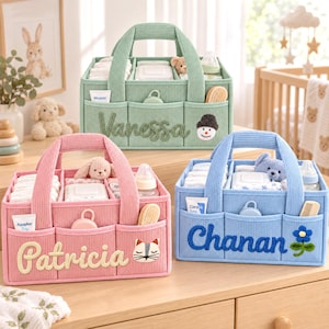 May include: Three rectangular corduroy storage caddies in sage green, light pink, and sky blue. Each caddy features three front pockets, two handles, and internal dividers. The caddies are embroidered with the names Vanessa, Patricia, and Chanan.