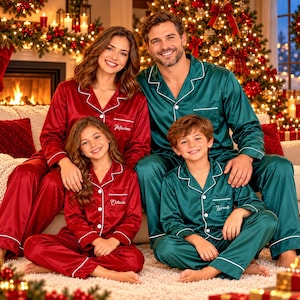 May include: Matching satin pajama sets in deep red and dark green with white piping and button-down shirts. The shirts feature embroidered names including Maxime, Octavia, and Tyreek on the chest pockets. The sets include long-sleeved tops and pants.