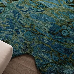 May include: Abstract area rug with a blue and green marbled pattern. The rug has an irregular shape with a curved edge.