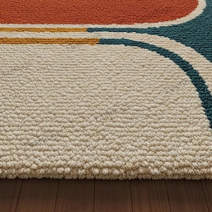May include: Close-up of a textured rug with a cream-colored background. The rug features a design with orange, yellow, and teal curved lines. The rug is made of a thick, durable material, and is placed on a wooden floor.