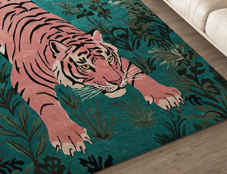 May include: A rectangular area rug featuring a large pink tiger with black stripes positioned in a prowling stance. The tiger is set against a deep teal background filled with dark green foliage and leaf patterns, creating a high-contrast design.