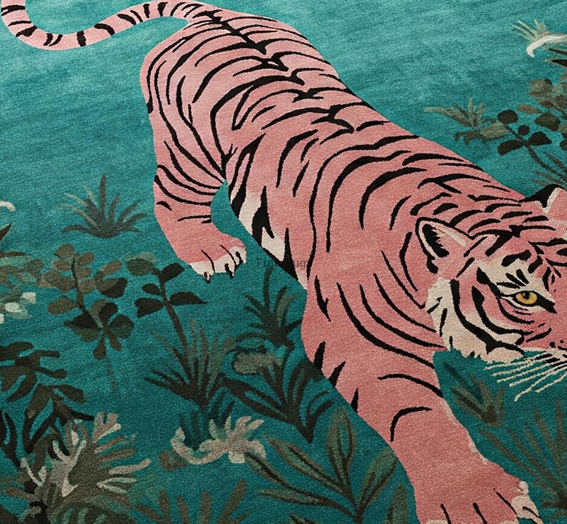 May include: A rectangular area rug featuring a large pink tiger with black stripes positioned diagonally across a vibrant teal background. The design includes dark green botanical foliage and plants scattered throughout the field.