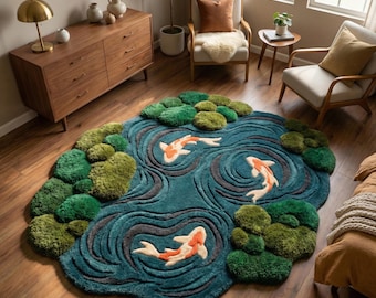 Könnte beinhalten: Ein teal-farbener, runder Teppich, der eine Koi-Teich-Szene darstellt. Der Teppich zeigt drei orange-weiß gestreifte Koi-Fische, die in einem Teich mit grünen Seerosen schwimmen. Der Teppich liegt auf einem Holzboden.