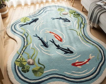 May include: A round rug with a pond design. The rug features a light blue background with a pond scene, including koi fish in red and black, lily pads, and water plants. The rug has a cream-colored border.