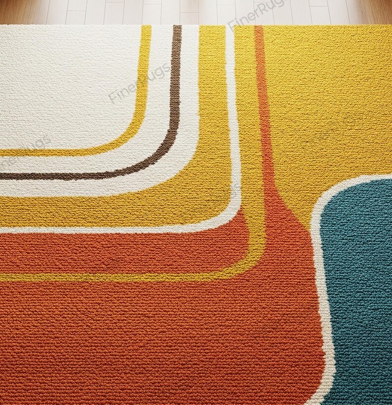 May include: A close-up of a retro-style rug with a textured surface. The rug features a color block design with orange, yellow, brown, and teal sections. White outlines define the curved shapes.