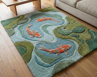 Könnte beinhalten: Rechteckiger Teppich mit einem Koi-Teich-Design. Der Teppich hat einen blauen Hintergrund mit grünen und blauen Wassermustern. Drei orangefarbene und weiße Koi-Fische schwimmen in dem Teich. Der Teppich liegt auf einem Holzboden.