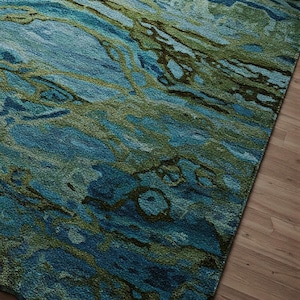 May include: Abstract area rug with a blue and green marbled pattern. The rug has a soft, textured feel and is perfect for adding a touch of modern style to any room.