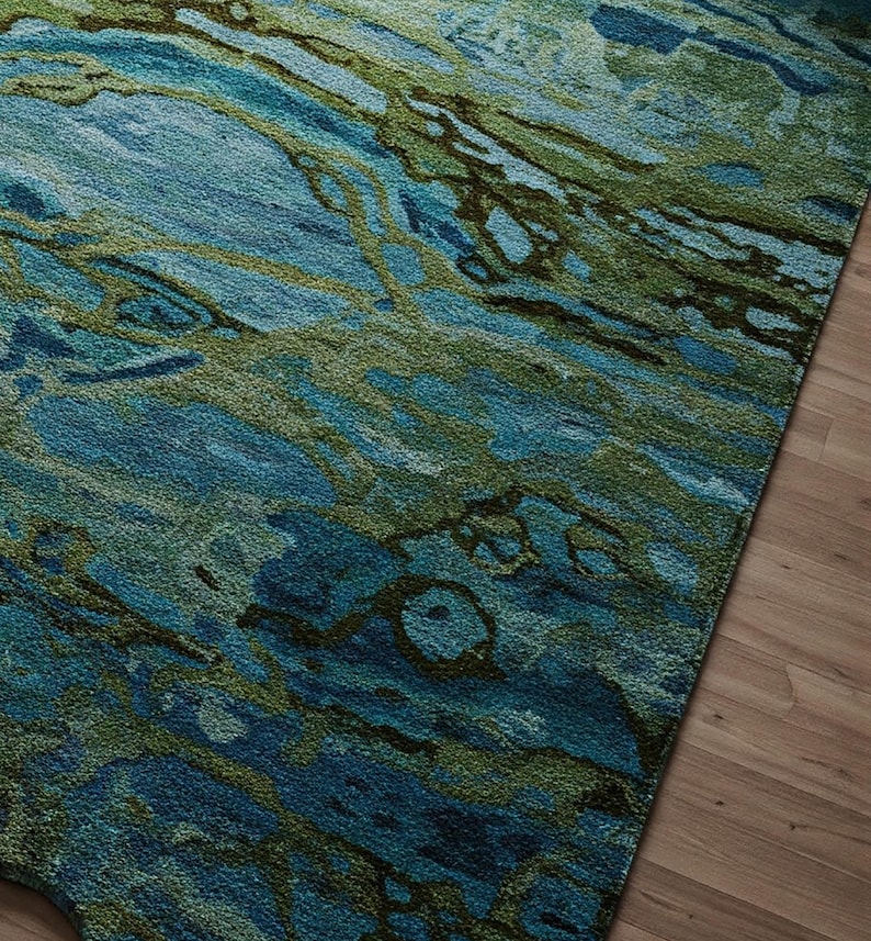 May include: Abstract area rug with a blue and green marbled pattern. The rug has a soft, textured feel and is perfect for adding a touch of modern style to any room.