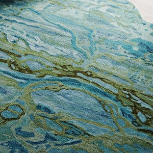 May include: Abstract area rug with a blue and green marbled design. The rug has a soft, textured surface.