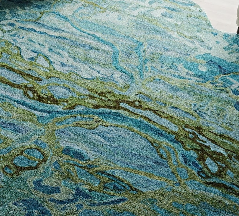 May include: Abstract area rug with a blue and green marbled design. The rug has a soft, textured surface.