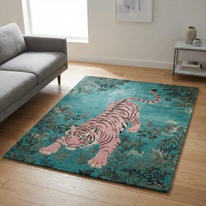 May include: A rectangular area rug featuring a large pink tiger with black stripes positioned in the center. The rug has a teal background decorated with dark green foliage and leaf patterns surrounding the tiger in a jungle-inspired design.
