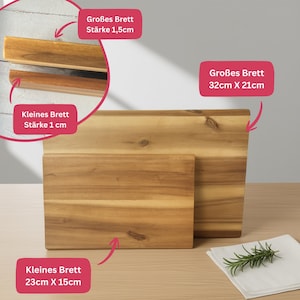 May include: Two wooden chopping boards are shown, one large and one small. The larger board measures approximately 32cm x 21cm and is 1.5cm thick. The smaller board is about 23cm x 15cm and is 1cm thick. The boards are made of light brown wood.