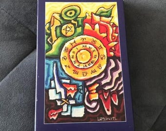 May include: A box for a Langustl Tarot deck. The box is blue with a colorful illustration of a clock face with Roman numerals and a star. The text "Langustl Tarot" and "Langustl Verlag" is printed on the box.
