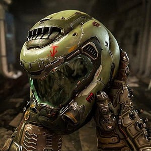 Puede incluir: Un casco verde y negro con un símbolo rojo en la parte delantera. El casco tiene una visera transparente y una superficie texturizada.