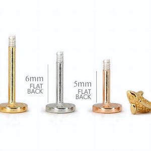May include: Three different sizes of flat back labret studs, 8mm, 6mm, and 5mm. The studs are made of gold, silver, and rose gold. The 8mm stud is gold, the 6mm stud is silver, and the 5mm stud is rose gold.