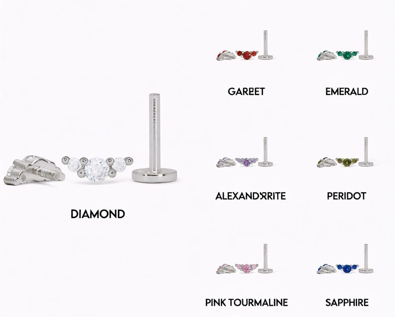 Op de afbeelding: Een zilverkleurige oorbel met platte achterkant en een gebogen staafje met drie ronde stenen. De set toont diverse edelsteenopties met de labels Diamond, Garnet, Emerald, Alexandrite, Peridot, Pink Tourmaline en Sapphire, elk met een stift.