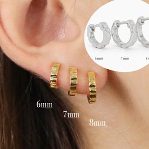 Könnte beinhalten: Drei goldene Creolen in verschiedenen Größen: 6 mm, 7 mm und 8 mm. Die Ohrringe sind an einem Ohr einer Person zu sehen.