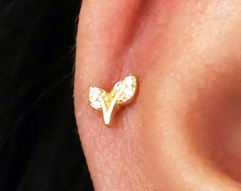 Puede incluir: Pendiente de oro en forma de hoja con piedras de circonita cúbica transparentes.
