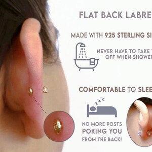May include: A gold-toned flat back labret earring made with 925 sterling silver. The text reads: FLAT BACK LABRET, MADE WITH 925 STERLING SILVER, NEVER HAVE TO TAKE THEM OFF WHEN SHOWERING!, COMFORTABLE TO SLEEP IN, NO MORE POSTS POKING YOU FROM THE BACK!