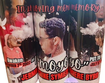 May include: A cylindrical tumbler featuring a memorial design with the text In Loving Memory, Awaken November 7th 2002, and Put To Rest July 5th 2023. The graphic includes portraits of a person, white doves, clouds, and the name Jermaine Symiere Byrd.