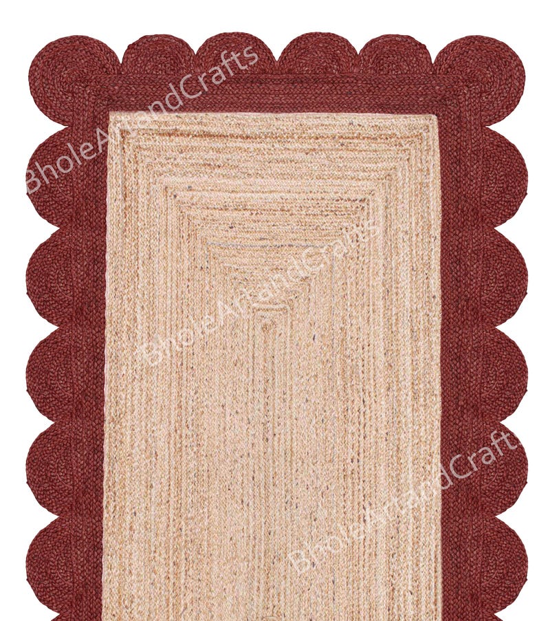 May include: A rectangular jute rug with a scalloped burgundy border. The inner section of the rug is a natural beige colour, with a woven texture. The border is a darker shade of red. The rug is suitable for home decor.