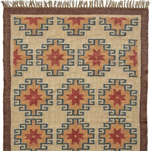 May include: A beige rug with a geometric pattern of red, orange, and blue stars. The rug has a brown fringe border.