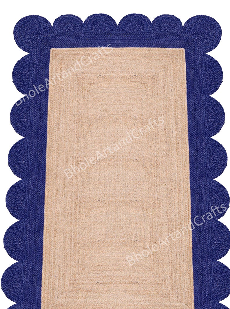May include: A rectangular jute rug with a navy blue scalloped border. The rug's central area is a natural beige colour, and the border adds a decorative element. The rug is suitable for indoor use.
