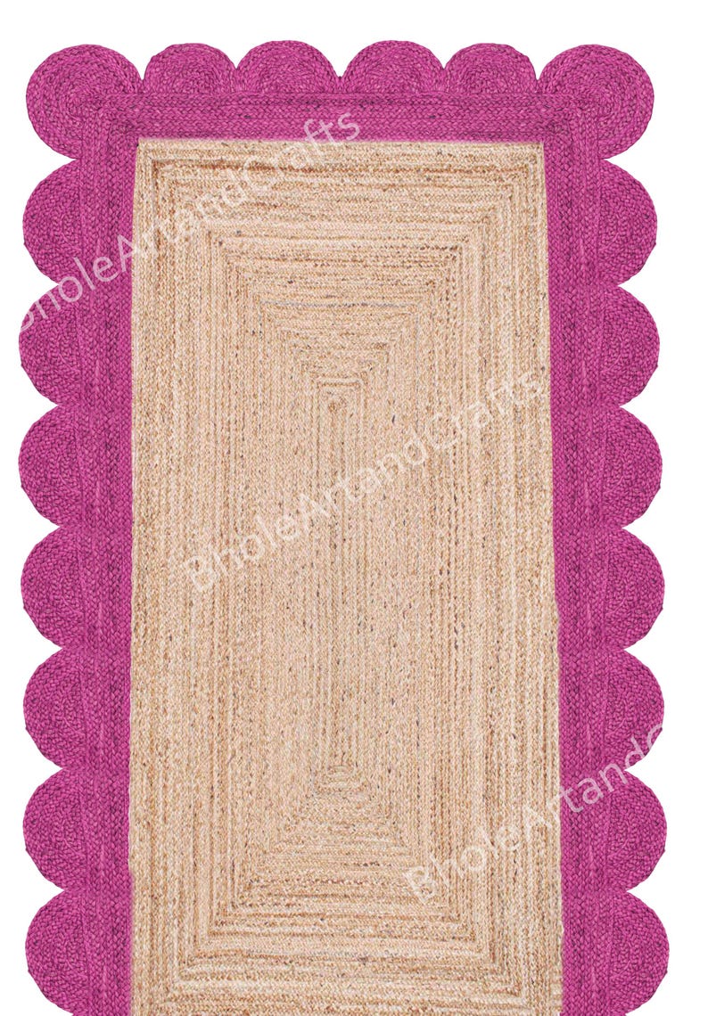 May include: A rectangular jute rug with a fuchsia scalloped border. The centre of the rug has a natural beige colour and a rectangular design. The rug is made of woven jute fibres.