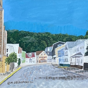 May include: An acrylic painting of a street scene with colorful houses and a church tower on the left. The houses are painted in various colors, including white, blue, green, and brown. The sky is a bright blue, and the road is gray. The artist's signature is in the bottom left corner.