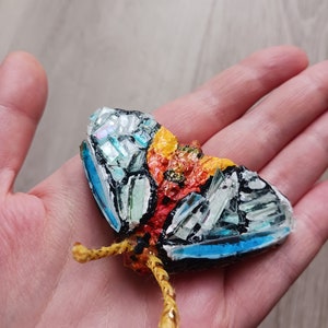 La piccola farfalla colorata di carta pesta