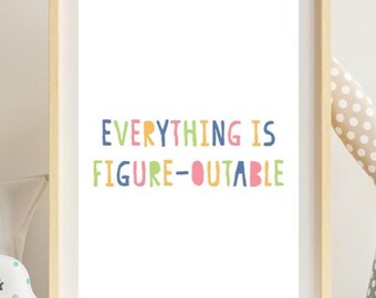 Op de afbeelding: Een ingelijste print met de tekst "EVERYTHING IS FIGURE-OUTABLE" in kleurrijke, speelse letters. De woorden zijn in een mix van blauw, geel, groen en roze. De lijst is licht van kleur en de print wordt op een wit oppervlak weergegeven.