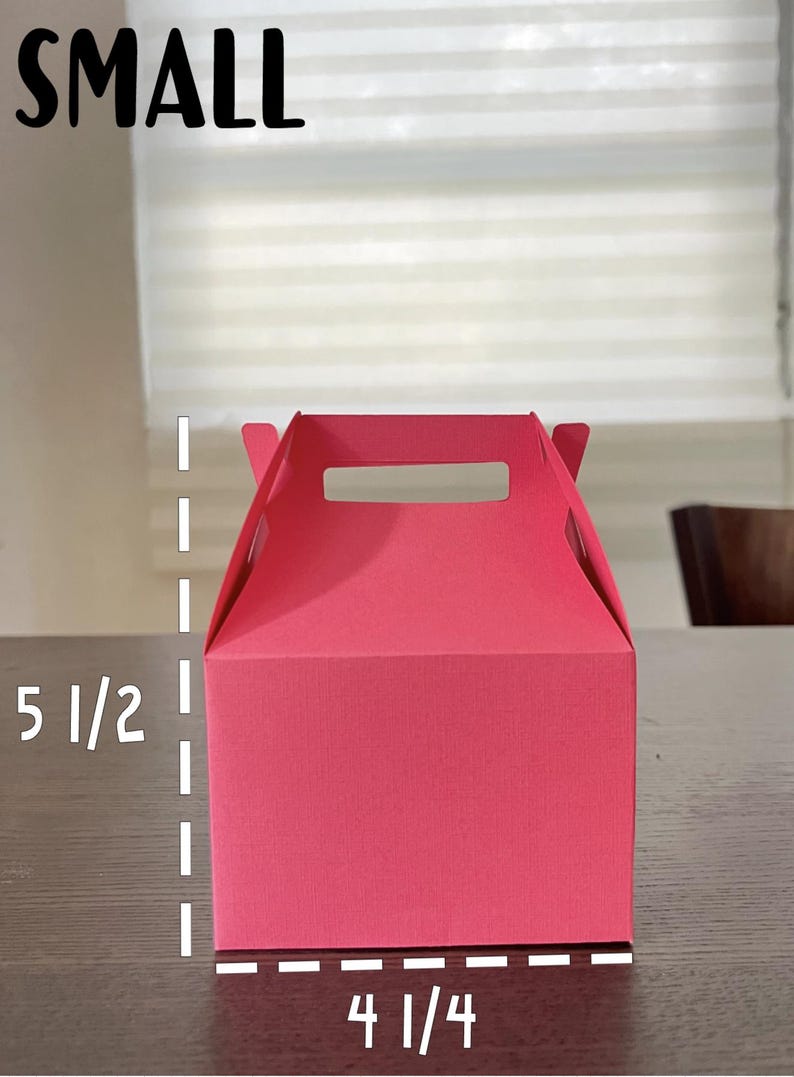 May include: A small, bright pink gift box with a handle. The box measures 5 1/2 inches tall and 4 1/4 inches wide.